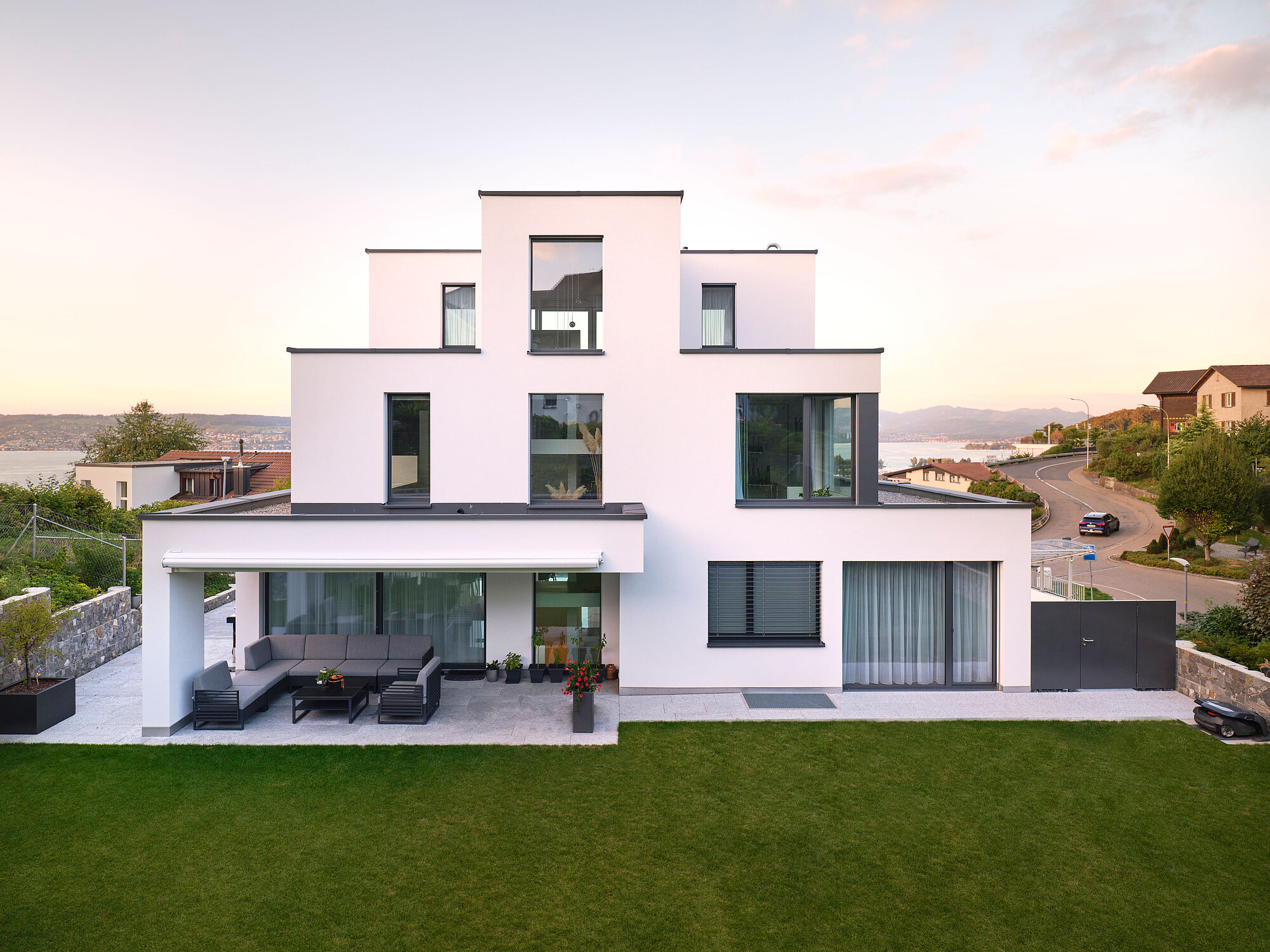[Translate to English:] Das Einfamilienhaus COAST in der Aussenansicht, Garten