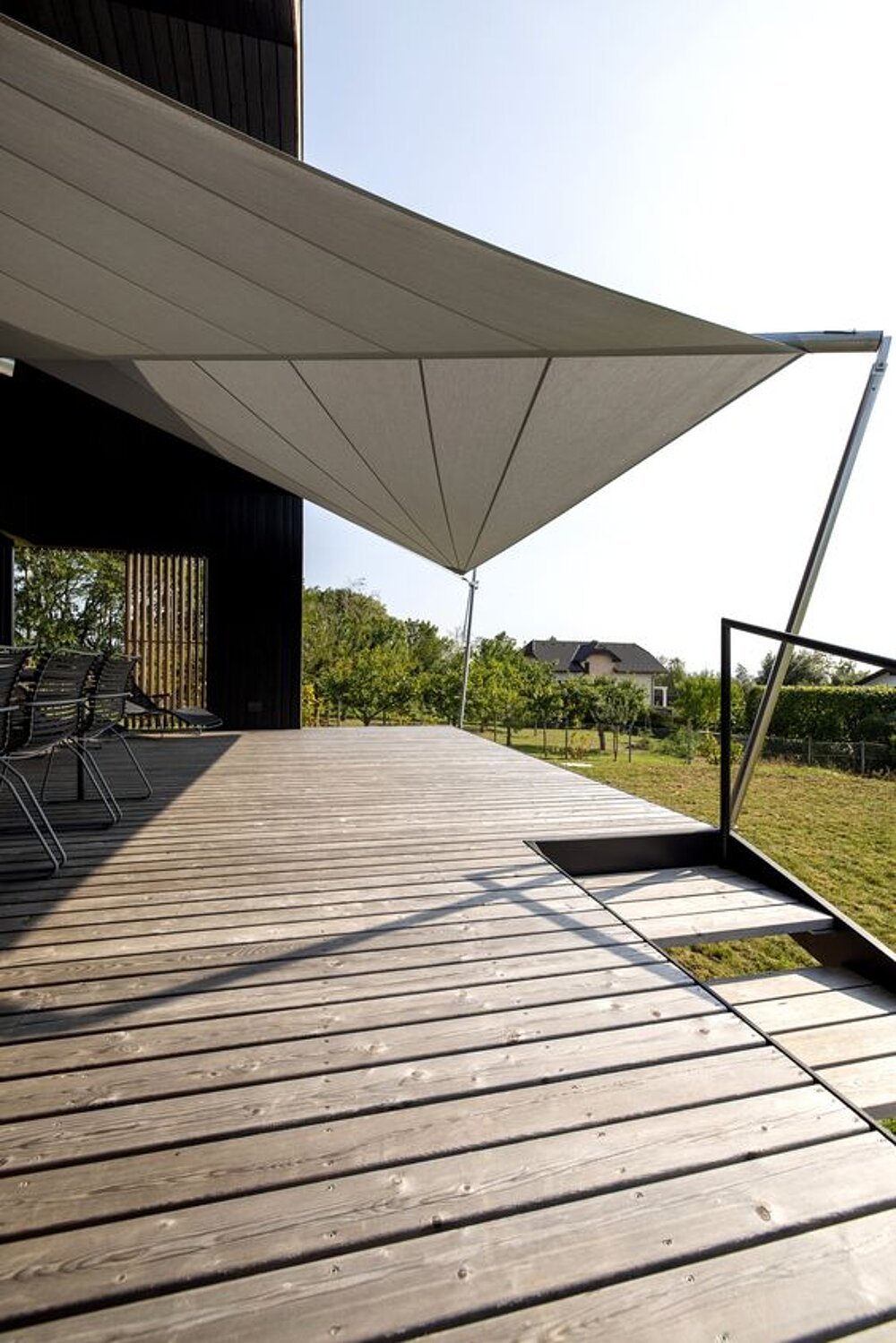 Timber terrace with a shade sail and views of the surrounding greenery