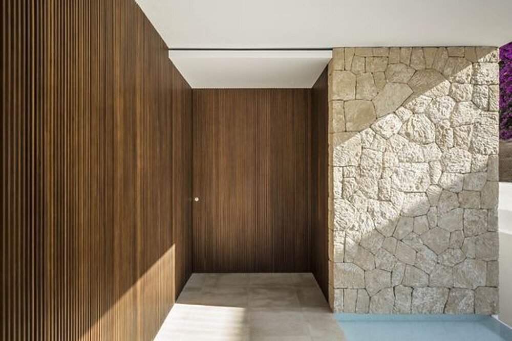 Entrance area with timber cladding and a natural stone feature wall